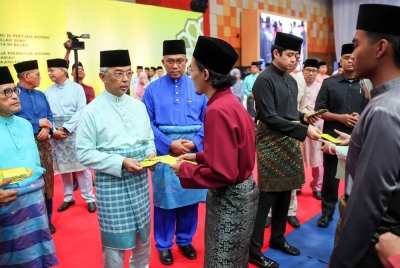 Al-Sultan Abdullah dan Tengku Hassanal berkenan mengurniakan sumbangan kepada 60 pelajar terdiri dari golongan yang memerlukan pada Majlis Berbuka Puasa Bersama Warga Universiti Malaysia Pahang (UMP) pada Jumaat. Turut kelihatan, Wan Rosdy dan Yuserrie - Foto Bernama