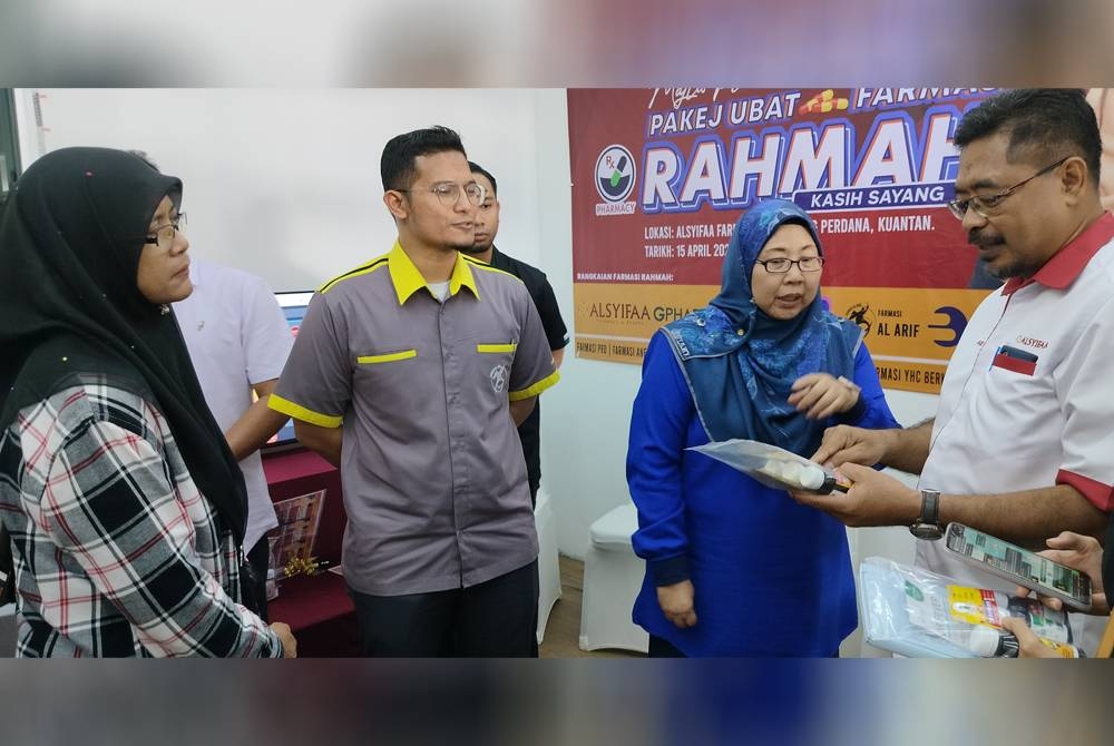 Fuziah (dua dari kanan) mendengar penerangan ringkas oleh Abdul Aziz ( kanan) mengenai pakej ubat yang ditawarkan di Farmasi AlSyifaa.