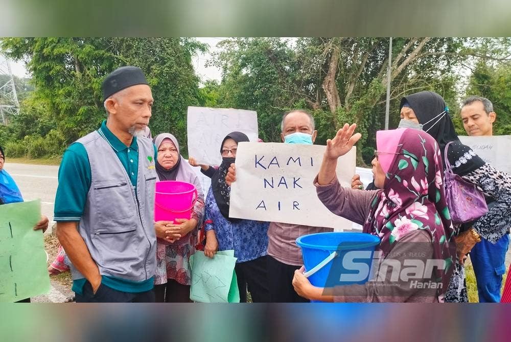 Hassan (kiri) ketika bertemu dan mendengar luahan penduduk kampung tersebut.