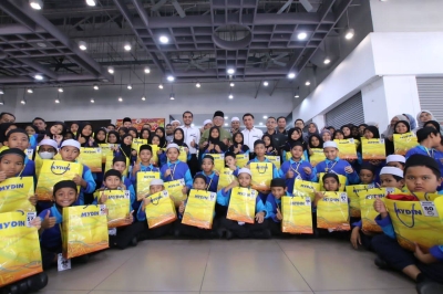 Amran (berdiri tengah) bersama 74 kanak-kanak dari Pusat Jagaan Inapan Kasih Sayang yang menerima sumbangan baju raya pada Sabtu.