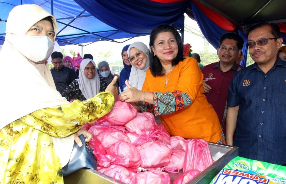 Saraswathy (dua dari kanan) menyertai jualan 'happy hour' sempena Jelajah Hari Usahawan Negeri Perak dan Jualan Ambang Aidilfitri Daerah Muallim di Dewan Seri Tanjung, Tanjung Malim pada Ahad.