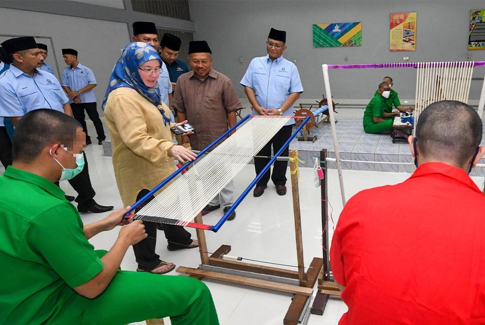 Tunku Azizah Aminah Maimunah Iskandariah berkenan meluangkan masa melawat bengkel tenun Pahang Diraja ketika berangkat tiba mencemar duli pada Majlis Memasak Bubur Lambuk bersama warga Penjara Penor pada Ahad. - Foto: Bernama