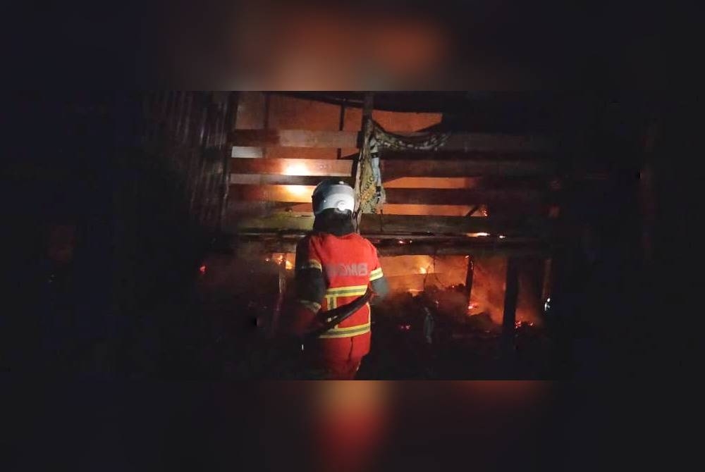 Anggota bomba berusaha memadamkan kebakaran di kandang kambing di Kampung Paya Batu Belengu pada Isnin. - Foto ihsan JBPM