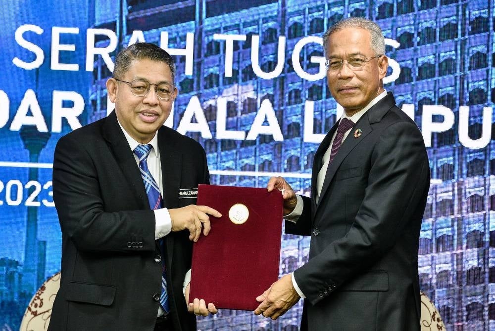 Kamarulzaman (kiri) menerima dokumen pelantikan beliau daripada Mahadi pada majlis serah terima tugas di Menara Dewan Bandaraya Kuala Lumpur pada Isnin. - Foto Bernama