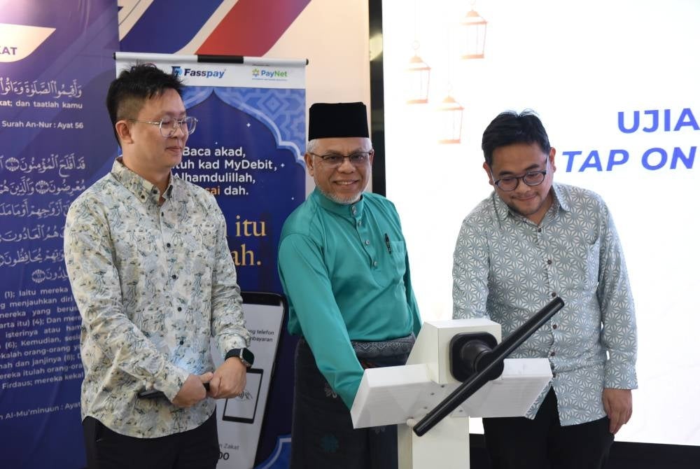 Abdul Hakim Amir Osman (tengah) ketika melancarkan Ujian Rintis Pembayaran Zakat sentuh pada telefon menggunakan Fasstap bagi pembayaran zakat fitrah di pejabat PPZ-MAIWP Taman Shamelin Perkasa, Kuala Lumpur.