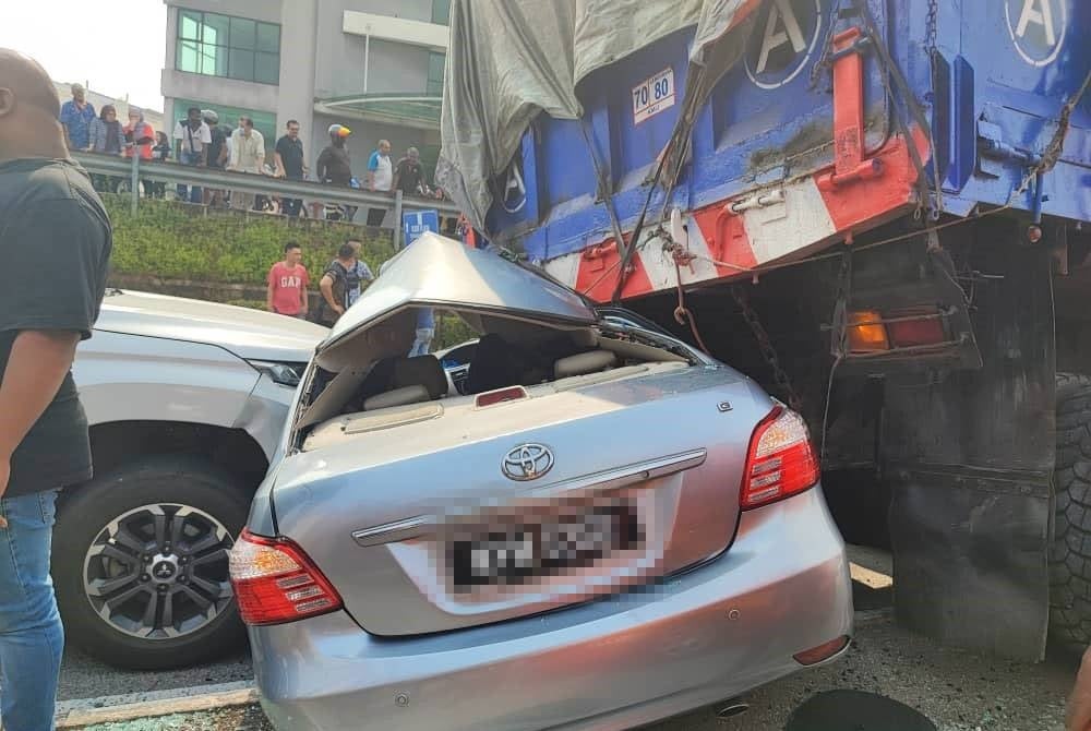 Sebuah kereta remuk teruk selepas dilanggar secara mengundur oleh treler membawa muatan pasir. 
