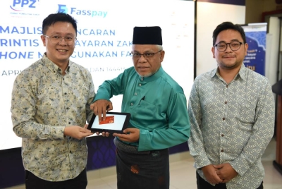 Abdul Hakim (tengah) melakukan gimik pelancaran Ujian Rintis Pembayaran Zakat sambil diperhatikan Johan Zep (kanan).