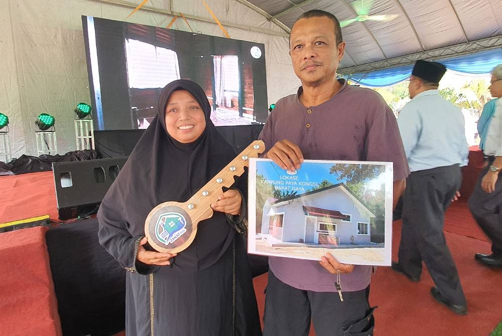 Peniaga kuih, Shahril Hasan, 56, dan isterinya gembira menerima replika kunci rumah Skim Inapan Kasih yang disampaikan Zakat Pulau Pinang.