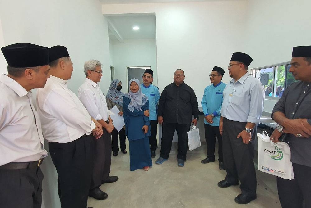 Ahmad Zakiyuddin (tiga dari kiri) ketika meninjau rumah yang disediakan untuk asnaf melalui Skim Inapan Kasih di Kampung Jarak Tengah, Tasek Gelugor pada Isnin.