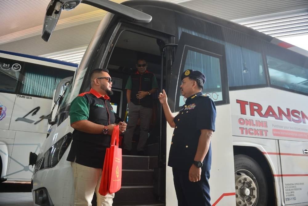 Ahmad Kamarunzaman beramah mesra bersama pemandu bas dalam Ops Hari Raya Aidilfitri 2023 di Terminal Bas Seksyen 17 di sini pada Rabu.