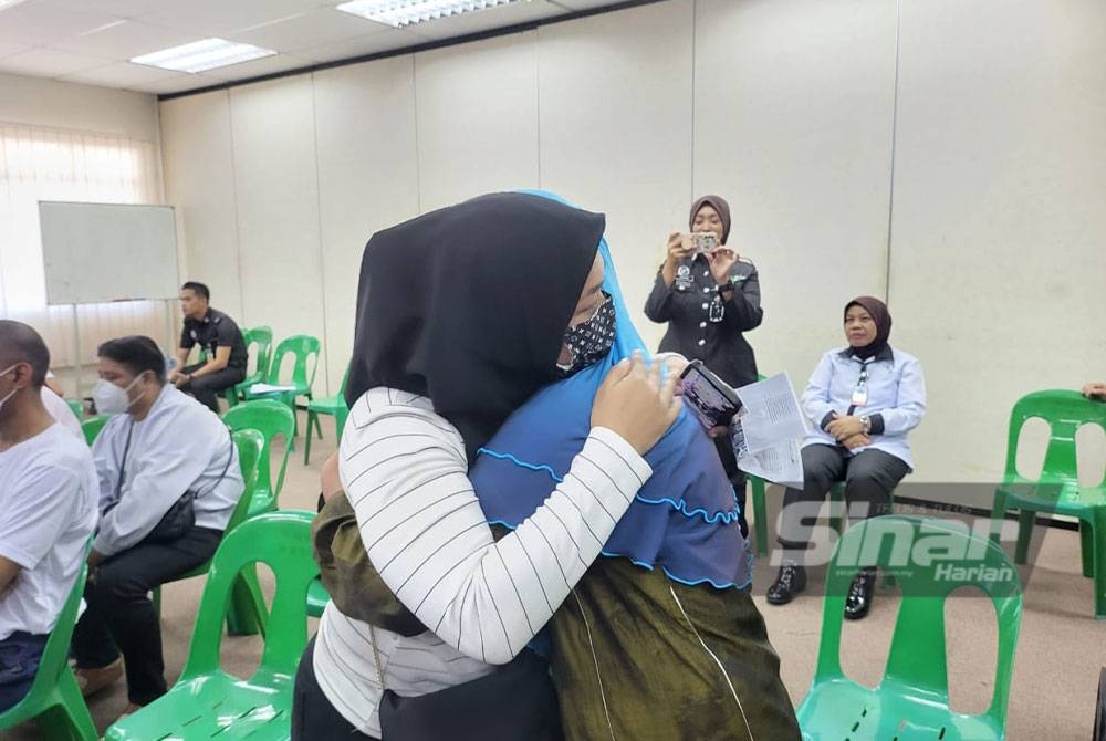 Mariam (kanan) memeluk kakaknya selepas diberikan pelepasan awal daripada hukuman.