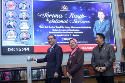 Dr Noor Hisham mengimbas kad perakam waktu pada hari terakhir bertugas di Kementerian Kesihatan, Putrajaya hari ini.
