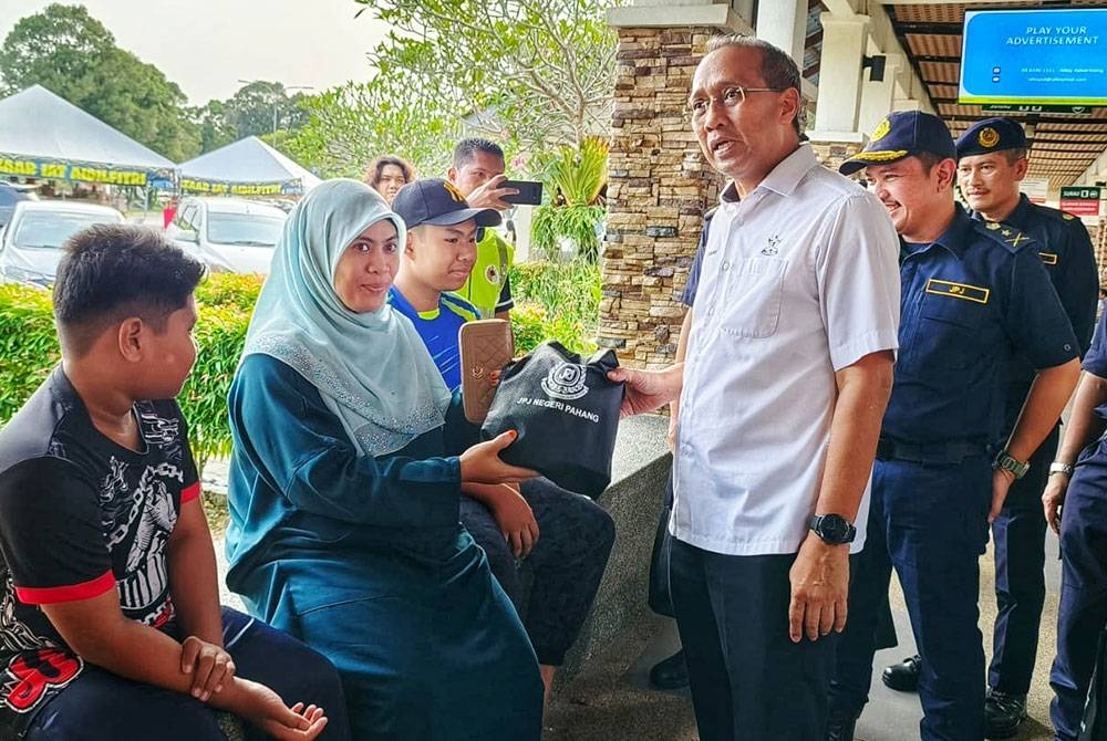 Mohammad Fakhruddin (kanan) ketika menyantuni pengguna di R&R Temerloh sempena jelajah mesra Kempen Keselamatan Jalan Raya sempena Aidilfitri 2023 pada Rabu.