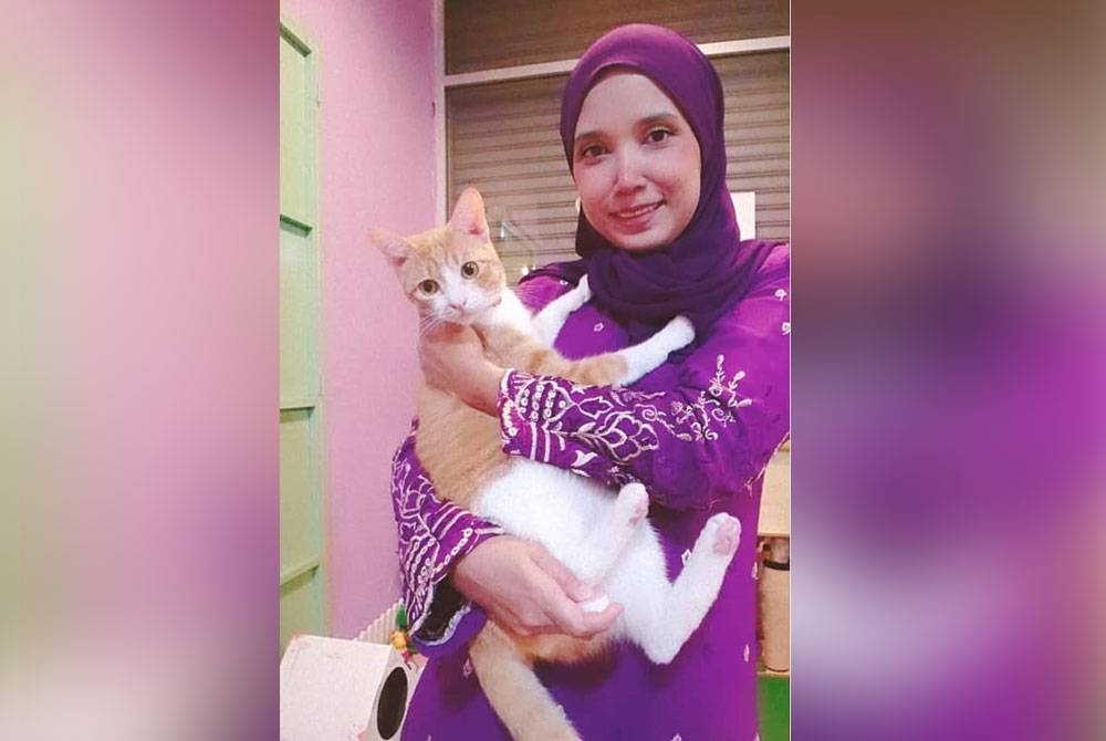 Noor Aini bersama salah satu kucing pelanggannya.