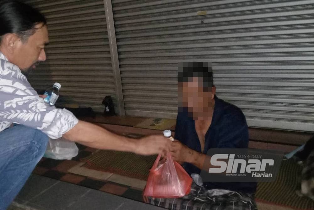 Sukimin (kanan) mengakui tidak janggal berbuka puasa dan menyambut Aidilfitri di laluan pejalan kaki di Jalan Tuanku Abdul Rahman.