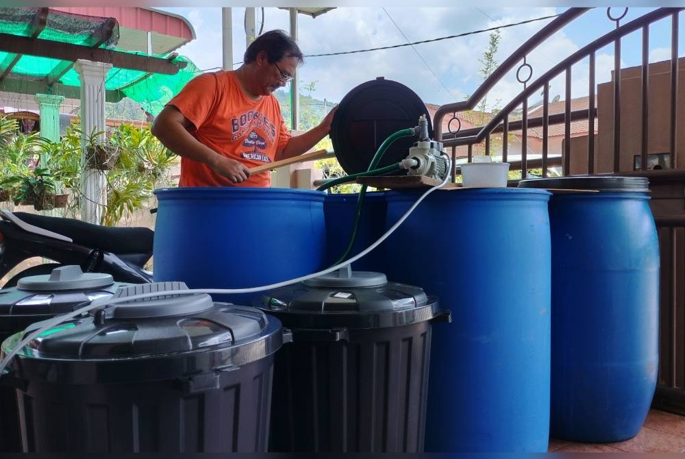 Alfian melihat kapasiti air yang disimpan dalam tong tambahan yang terpaksa dibeli setelah bekalan terganggu lebih 40 hari lalu.