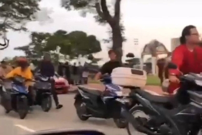 Mat rempit yang lengkap berbaju Melayu menolak motosikal mereka selepas ditahan kerana membuat bising dan aksi berbahaya di Dataran Penggaram di Bandar Batu Pahat pada Sabtu.