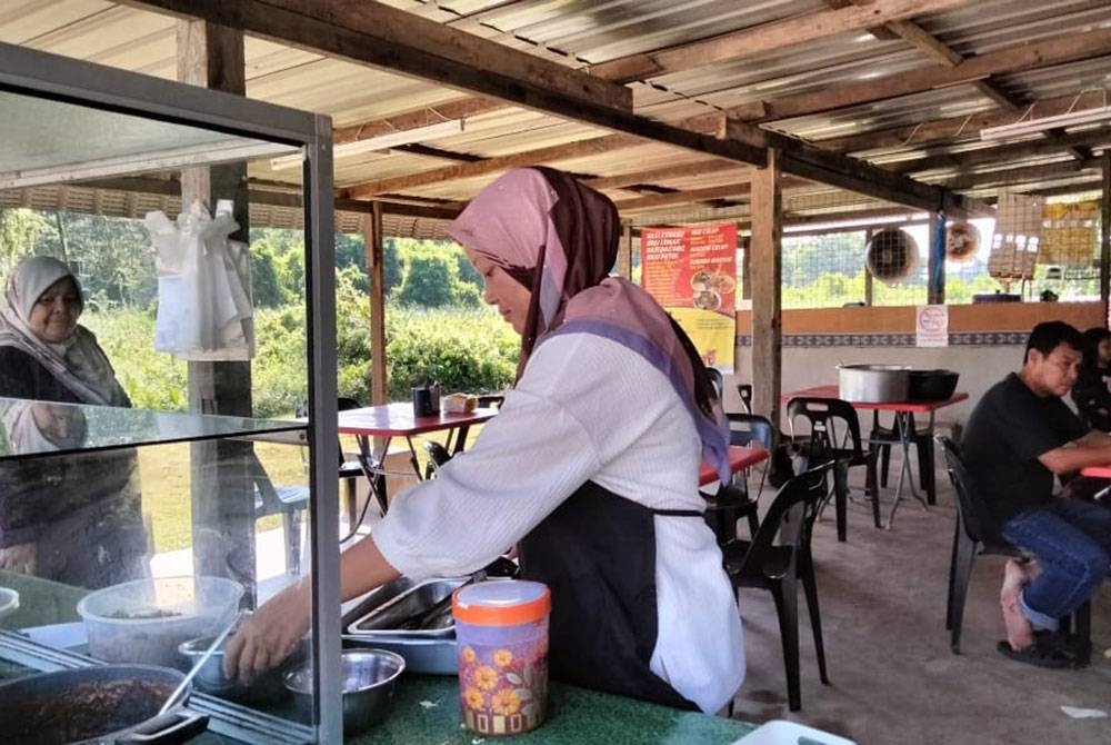 Hasmaizan mengemas peralatan jualan di kedainya di Kampung Belimbing, Tanah Merah.