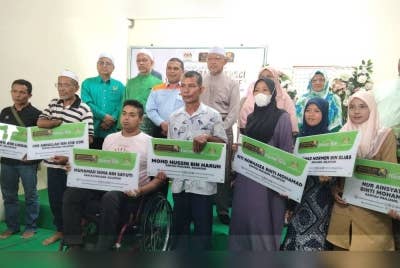 Ahmad (belakang, empat dari kiri) bersama penerima Rumah 'Home2Live' pada Rabu.