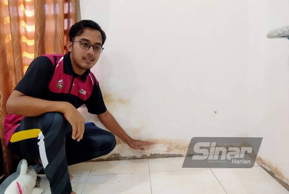 Muhammad Faiz menunjukkan paras lumpur yang memenuhi ruang rumahnya dalam kejadian banjir kilat pada Isnin lalu.