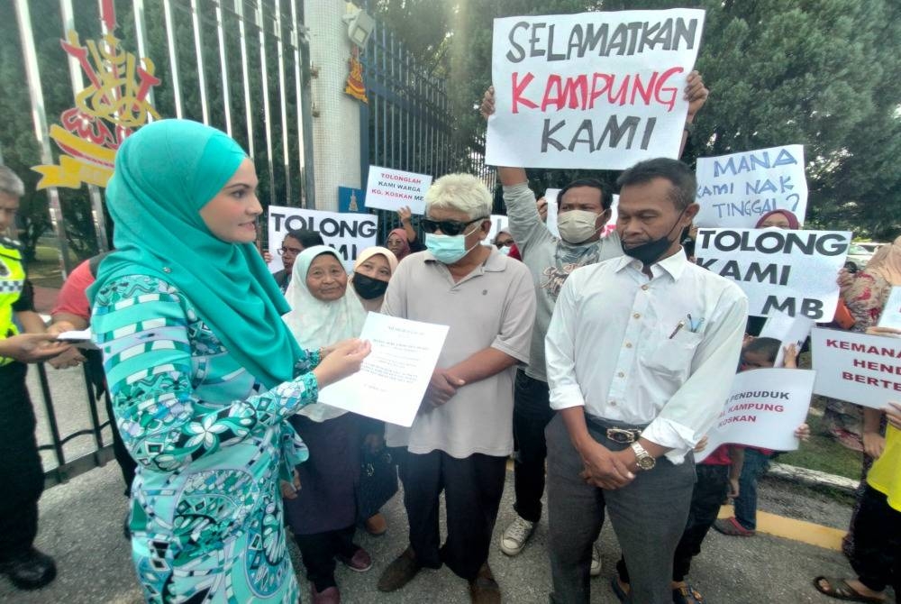 Maszahar (kanan) menyerahkan memorandum kepada Norbaini (kiri) di pintu masuk utama Pejabat Setiausaha Kerajaan Negeri Selangor pada Khamis.