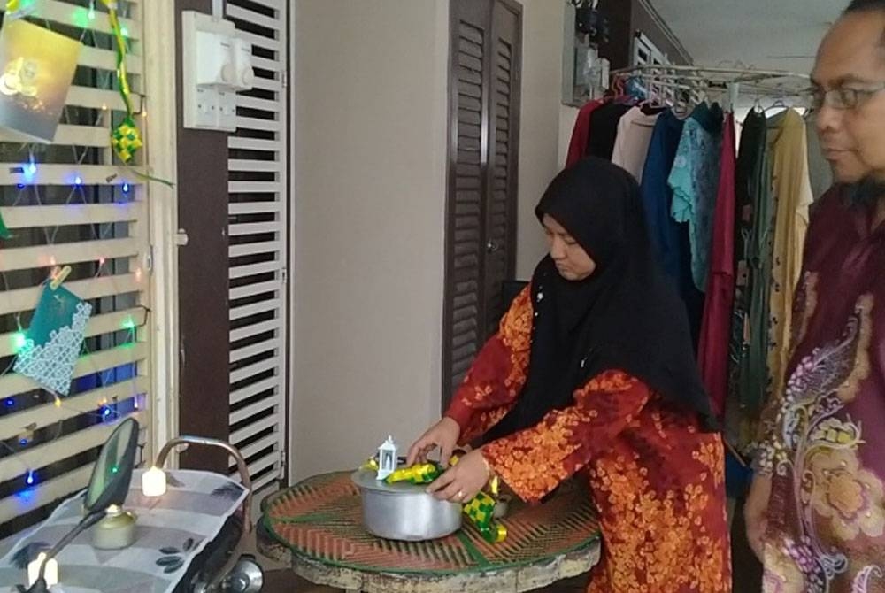 Roslina bersama suami menghias rumah mereka bagi menceriakan sambutan Hari Raya Aidilfitri di Taman Meru Perdana 2 di sini.