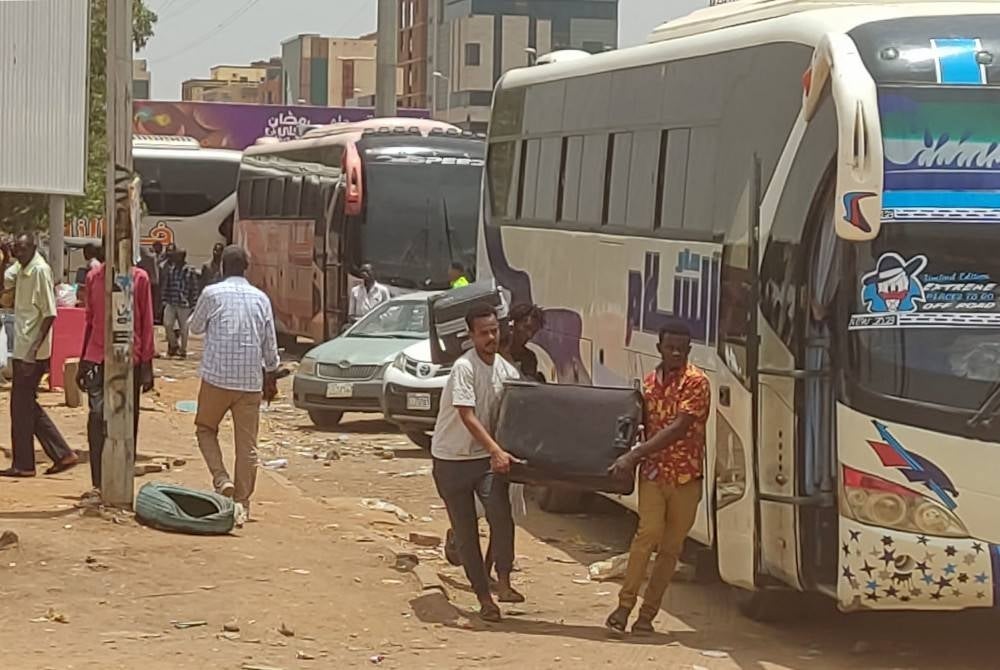 Orang ramai larikan diri ketika pertempuran jalanan antara tentera dan separa tentera pada Khamis. - Foto AFP