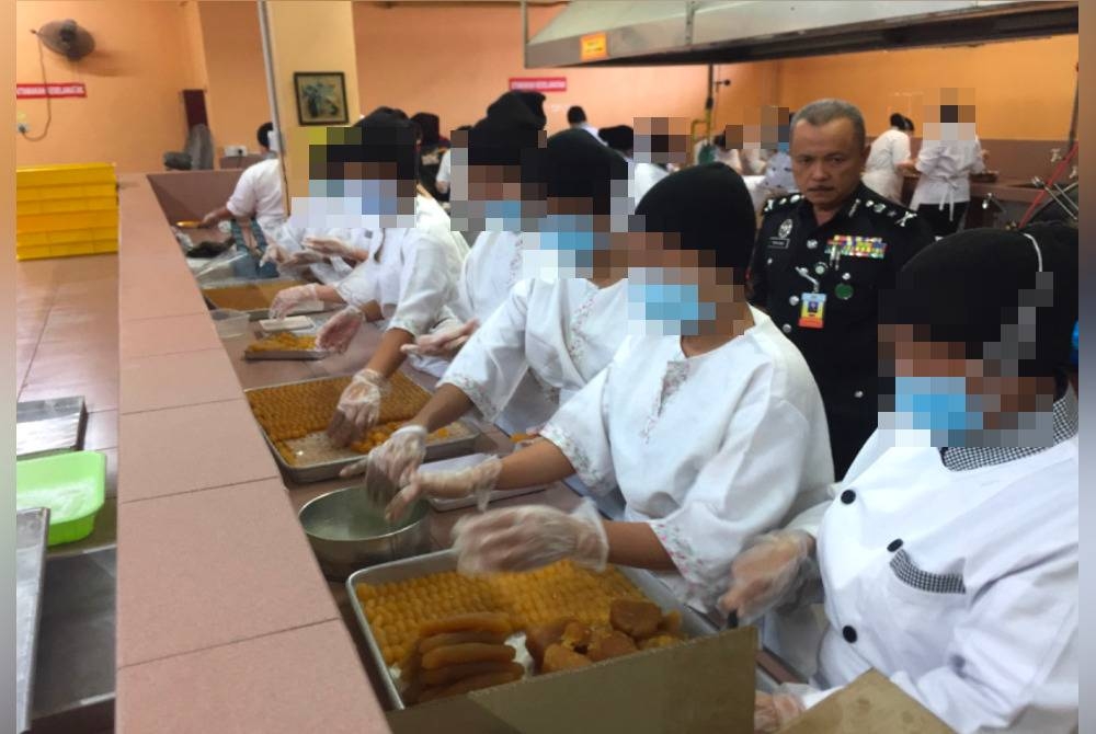 Banduan bersama-sama melakukan kerja persiapan inti biskut.