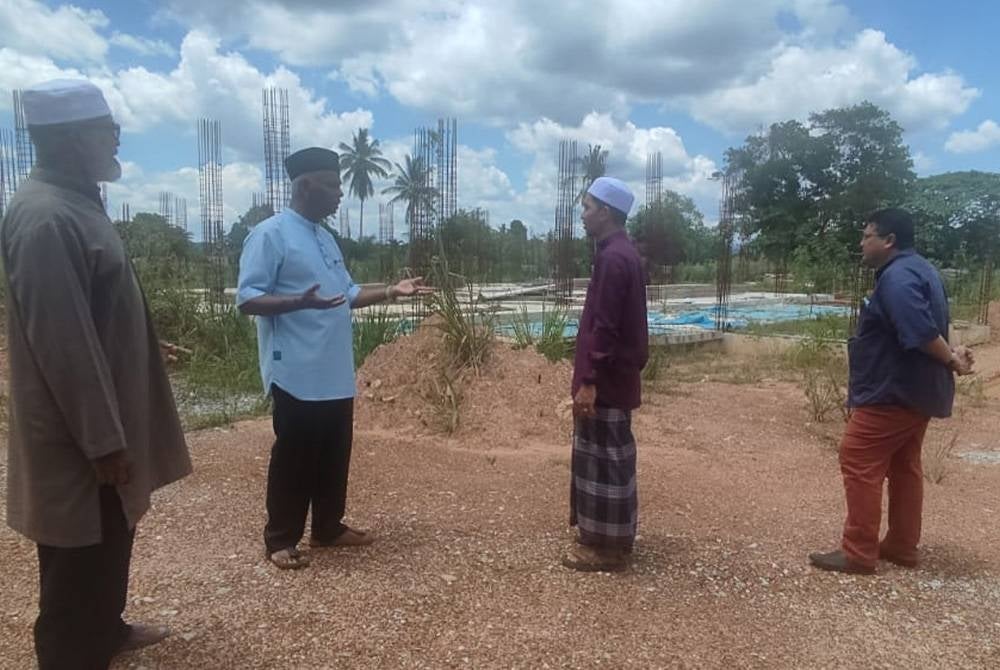 Zainol Abidin (kiri) dan Hasrul semasa melawat tapak masjid baharu Changlun yang gagal disiapkan kerana terhenti semasa PKP.