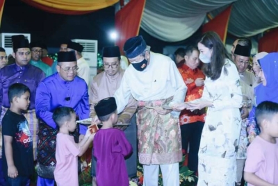 Sultan Sharafuddin (tiga dari kanan) dan Tengku Permaisuri Norashikin (dua dari kanan) berkenan menyampaikan duit raya kepada kanak-kanak yang hadir pada Program Rumah Terbuka Jelajah Kita Selangor Aidilfitri Daerah Klang. Turut mengiringi baginda, Amirudin (kiri) dan isteri, Masdiana (kanan).