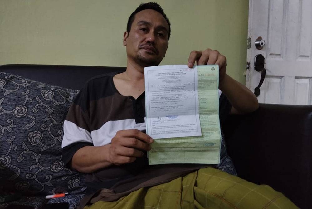 Syahrol Azmi menunjukkan perakuan daripada pihak HEBHK berhubung punca kematian anaknya, Airiel Syahren.