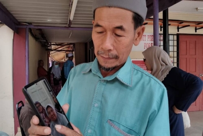 Suhaimi menunjukkan gambar kakaknya ketika ditemui di Unit Forensik Hospital Machang pada Selasa.