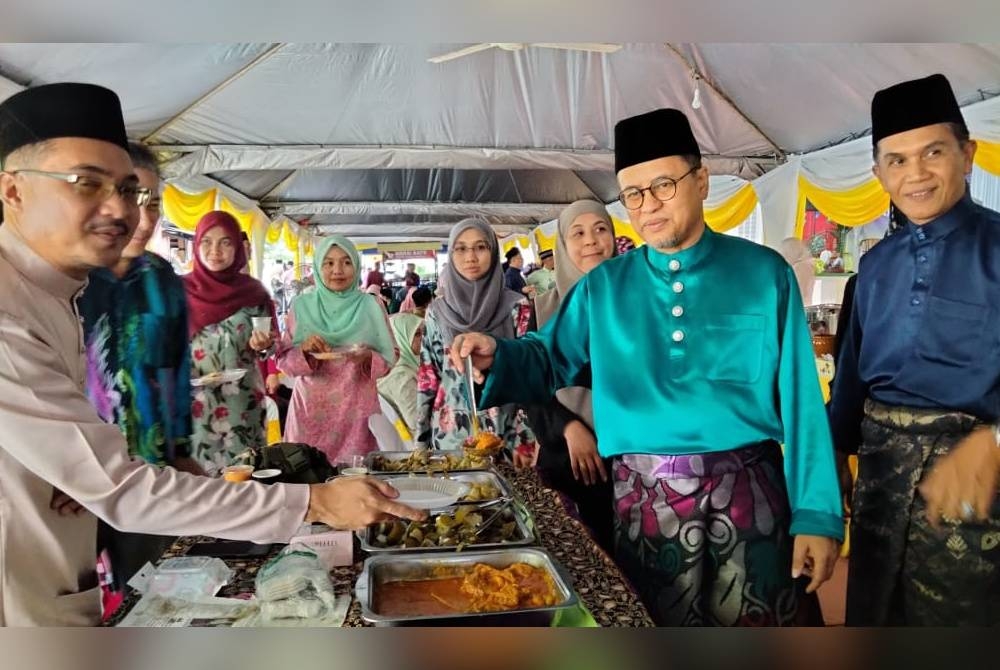 Azman (dua dari kanan) meraikan kakitangan pada Majlis Ramah Mesra Aidilfitri KPDN di sini pada Rabu.