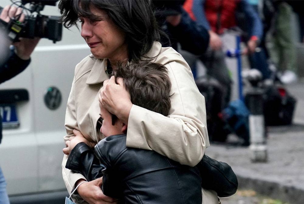 Des parents emmènent leurs enfants dehors après une fusillade dans une école à Belgrade.  -Photo AFP