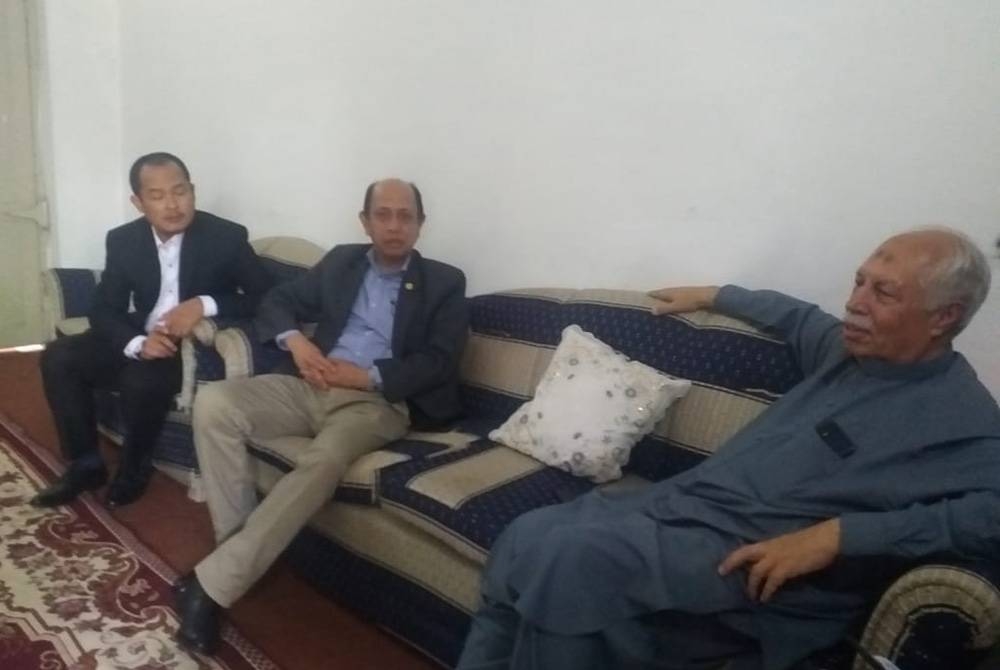 Tahir (kanan) meluangkan masa berbual bersama Mohammad Azhar (kiri) di kediamannya di Hissari Nehri, Pakistan pada Rabu.