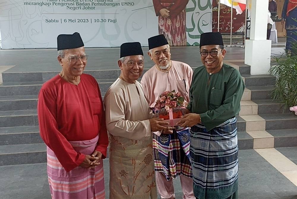Mohamed Khaled (kanan) menerima cenderamata daripada Othman (dua dari kiri) pada Majlis Mesra Ria Aidilfitri Veteran UMNO Johor pada Sabtu.