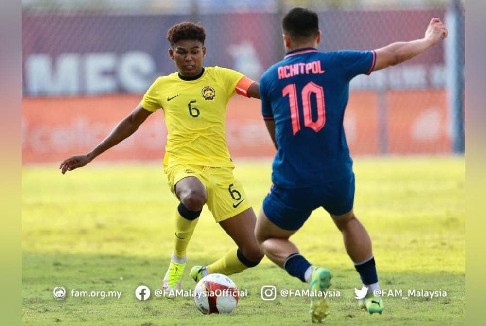 Kapten skuad negara, Azam Azmi Murad (kiri) mengawal pergerakan pemain Thailand yang menyaksikan pasukan lawan menang 2-0 dalam aksi Kumpulan B Sukan SEA Kemboja 2023 di Phnom Penh pada Sabtu. - Foto Facebook FAM.