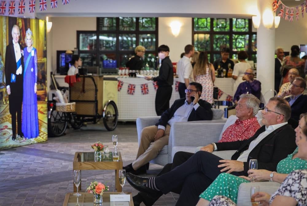 Pesuruhjaya Tinggi Britain ke Malaysia, Charles Hay (duduk, kanan) bersama rakyat Britain di sini ketika mereka menyertai berjuta-juta orang di seluruh dunia menyaksikan upacara pertabalan bersejarah Raja Charles III, pada Sabtu. - Foto Bernama