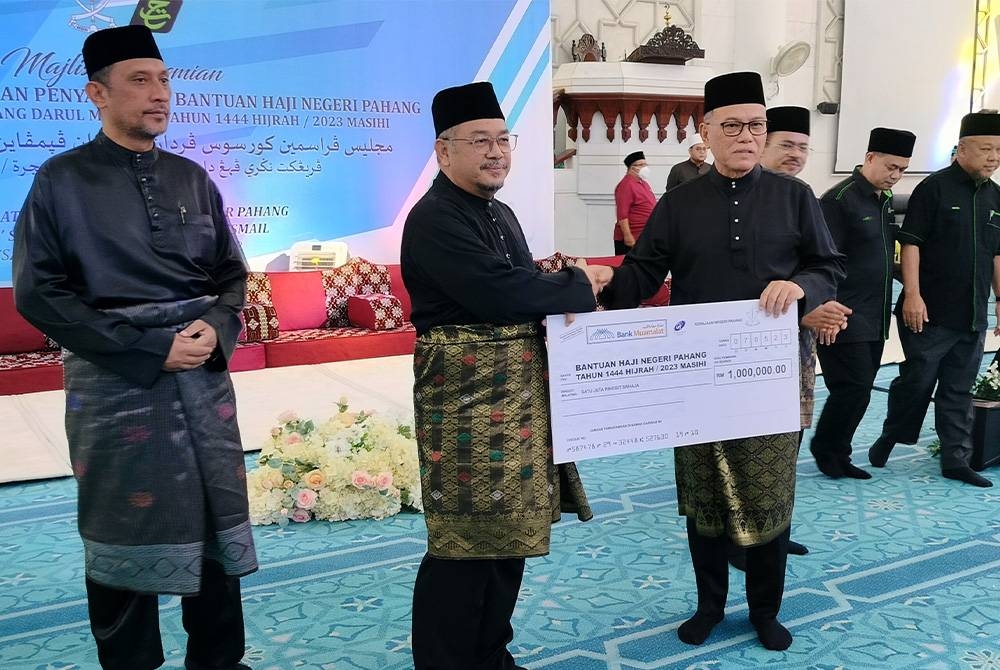 Wan Rosdy (à droite) a remis un chèque pour Bantuan Prihatin Pahang à Zulkifle pour être distribué aux futurs pèlerins de Pahang qui se rendront en terre sainte cette année.