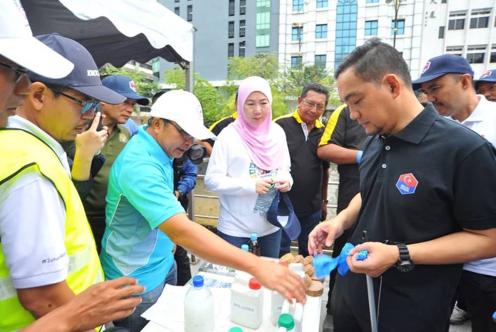Onn Hafiz diberi penerangan mengenai myd ball semasa Program Gotong Royong Johor Bersih di Sungai Segget, Johor Bahru pada Ahad