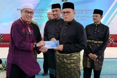 Wan Rosdy menyampaikan sumbangan tunai kepada salah seorang bakal haji sempena Majlis Perasmian Kursus Haji Perdana dan Penyampaian Insentif Haji Peringkat Negeri Pahang 2023 di Masjid Negeri Sultan Ahmad 1 di sini pada Ahad.