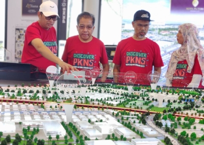 Md Kamarzan (dua dari kiri) melihat model pelan kawasan pembangunan Kota Puteri di sini.