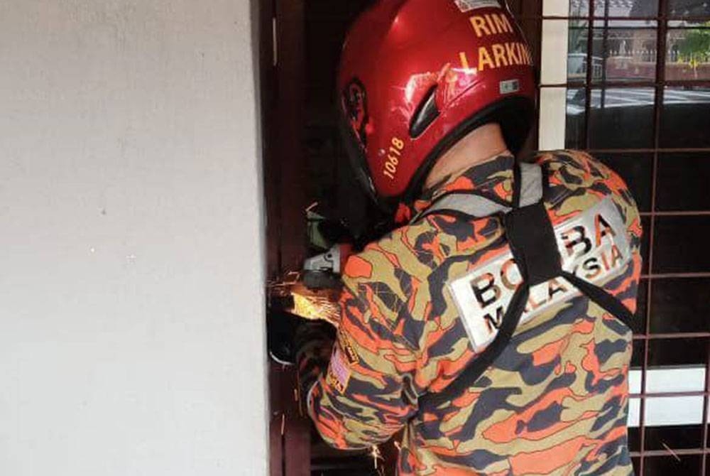 Anggota bomba memotong mangga 'grill' semasa melakukan kerja-kerja menyelamat seorang warga emas dalam sebuah rumah di Taman Suria, Johor Bahru pada Selasa