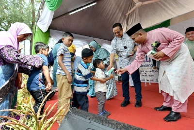 Ahmad Samsuri (dua dari kanan) melayani tetamu yang hadir sempena Majlis Hari Raya DUN Rhu Rendang di Pantai Peranginan Kelulut di Marang pada Selasa.