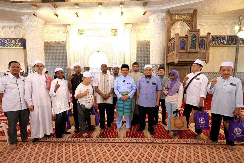 Mohd Na'im (lima dari kanan) bergambar dengan saudara baharu yang memeluk Islam di Masjid Negara.