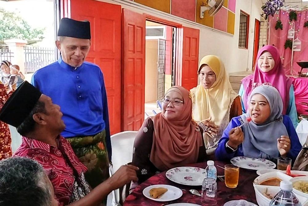 Razak menyantuni sebahagian tetamu yang hadir dalam sambutan tersebut