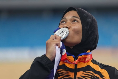 Atlet lompat bergalah wanita negara Nor Sarah Adi mencium pingat perak yang diperolehnya.- Foto: Bernama