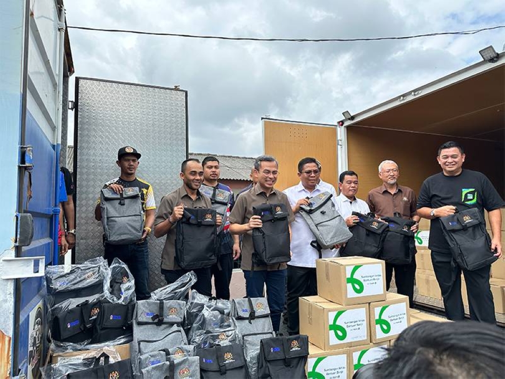 Maxis bersama-sama Menteri Komunikasi dan Digital, Fahmi Fadzil menyampaikan kotak makanan kepada mangsa banjir di Johor.