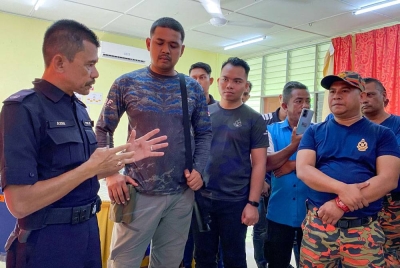 Timbalan Ketua Polis Gua Musang, DSP Azmi Mokhtar (kiri) memberi taklimat kepada pasukan penyelamat yang menyertai operasi SAR seorang lelaki Orang Asli yang dilaporkan hilang ketika memancing bersama anak saudaranya, Alang Kuang berusia lapan tahun di Kampung Aring 5, hari ini. - Foto Bernama