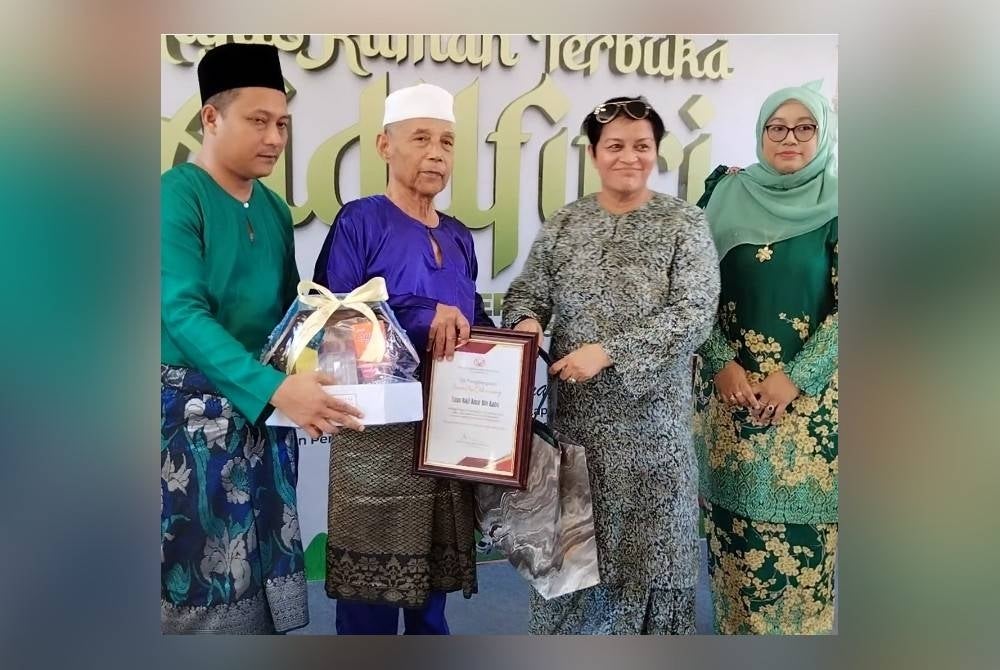 Azalina menyampaikan cenderahati kepada veteran UMNO pada Majlis Rumah Terbuka Aidilfitri Parlimen Pengerang di Dewan Kejora, Bandar Penawar, Kota Tinggi pada Jumaat.